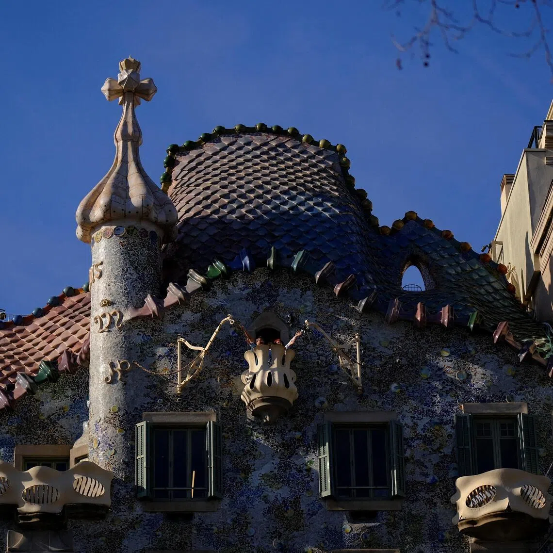 Tourists pose for a picture on a balcony of Casa Batllo, designed by architect Antoni Gaudi, at Passeig De Gracia in Barcelona, Spain on Feb 24, 2026. 