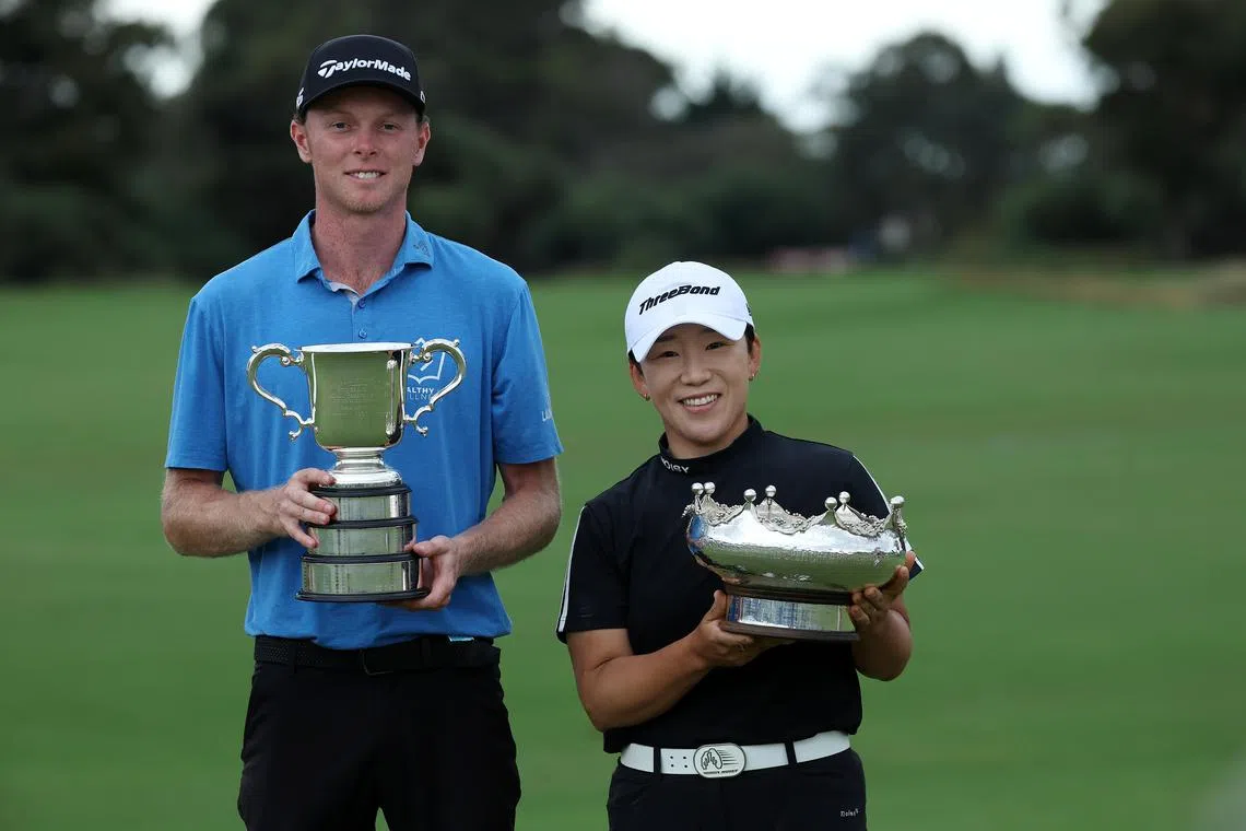 Ryggs Johnston and Jiyai Shin pose for a photo with their winners' trophies at the Australian Open.