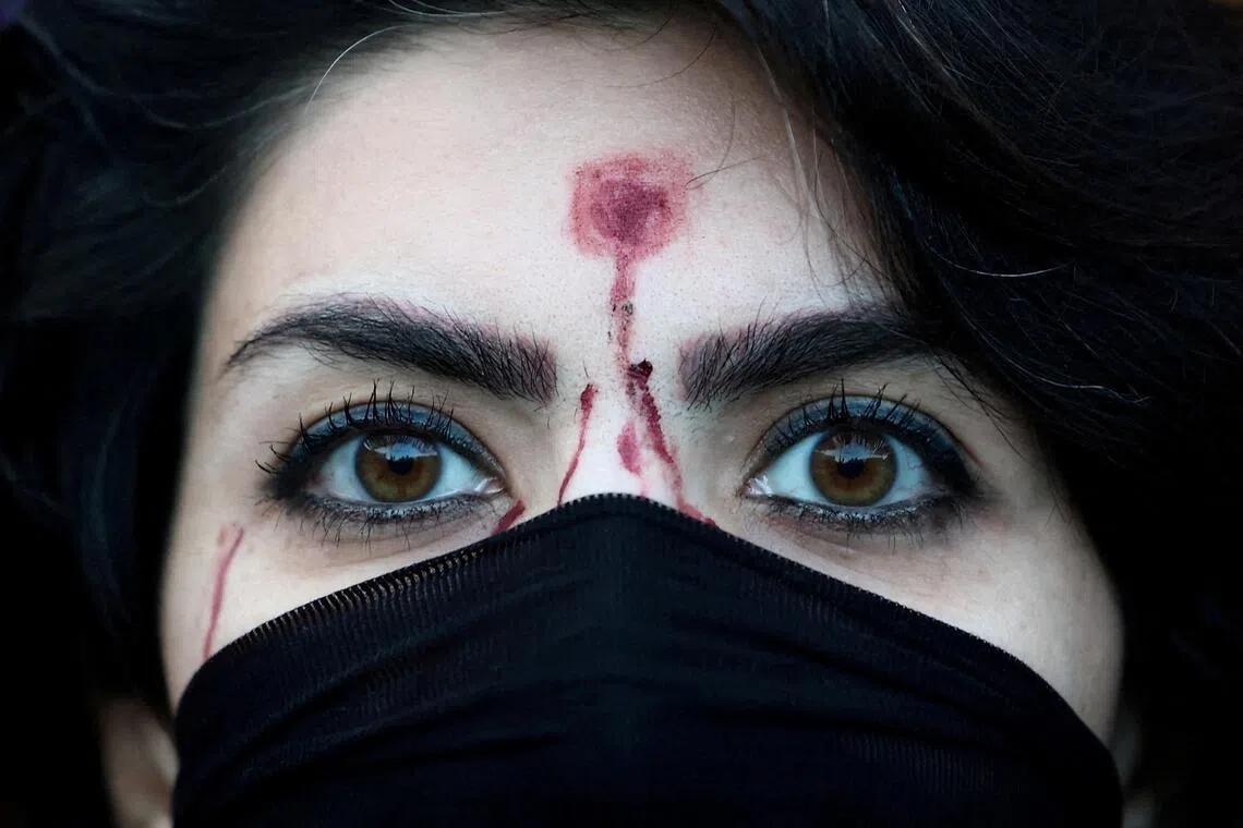 A woman in with a mock-up of a gunshot wound on her forehead attending a Jan 13 rally in Rome, Italy, to support nationwide anti-government protests in Iran.
