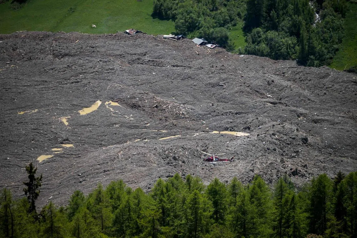 A helicopter flies above the landslide area on May 29 after part of the huge Birch Glacier collapsed.
