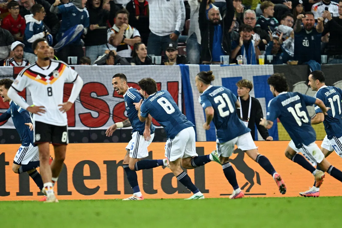 Greece’s Dimitrios Kourbelis celebrates scoring their first goal with teammates.