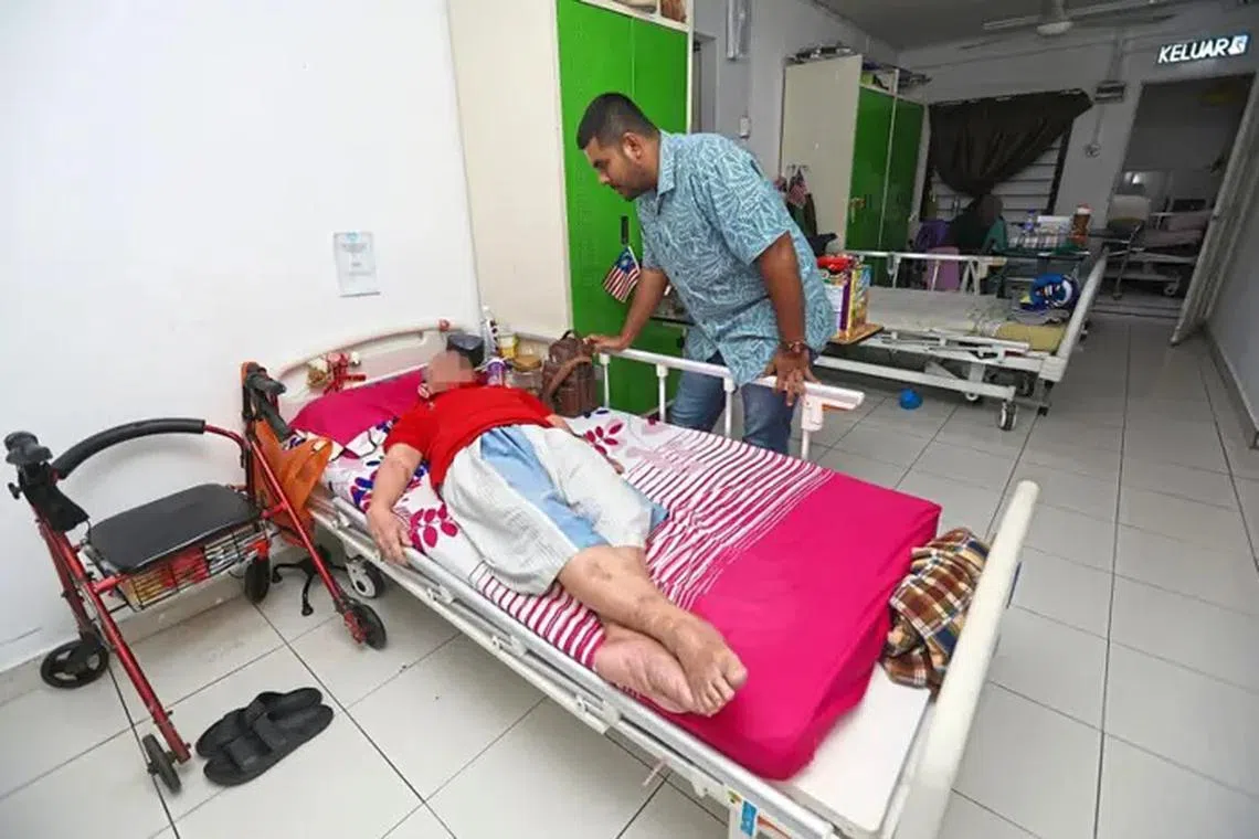 Mr Muhammad Syafiq checking on an elderly resident at Pusat Jagaan Mahmudah Malaysia in Selangor.
