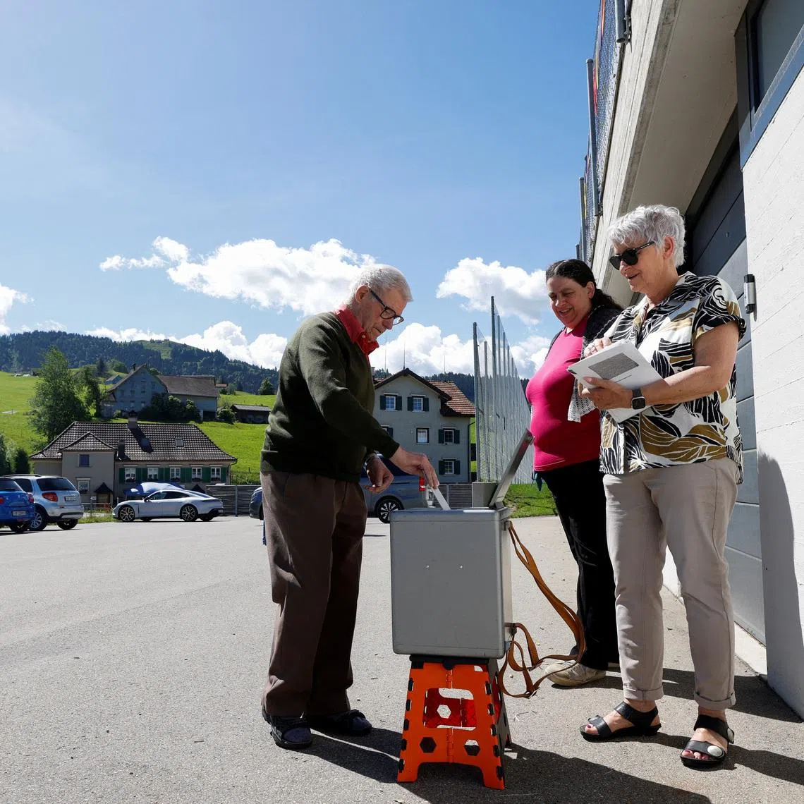 People vote in front of the school on a plan backed by the right-wing Swiss People's Party (SVP) to limit population growth to 10 million inhabitants, in Hundwil, Switzerland, June 14, 2026.  REUTERS/Michaela Stache