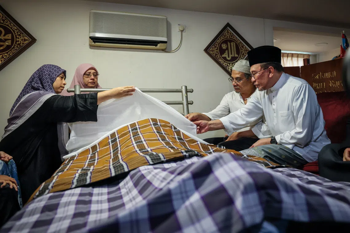 Prime Minister Anwar (far right) and his wife, Wan Azizah Wan Ismail, arrived at the family home at 11.05am to pay their last respects and offer condolences to the family.