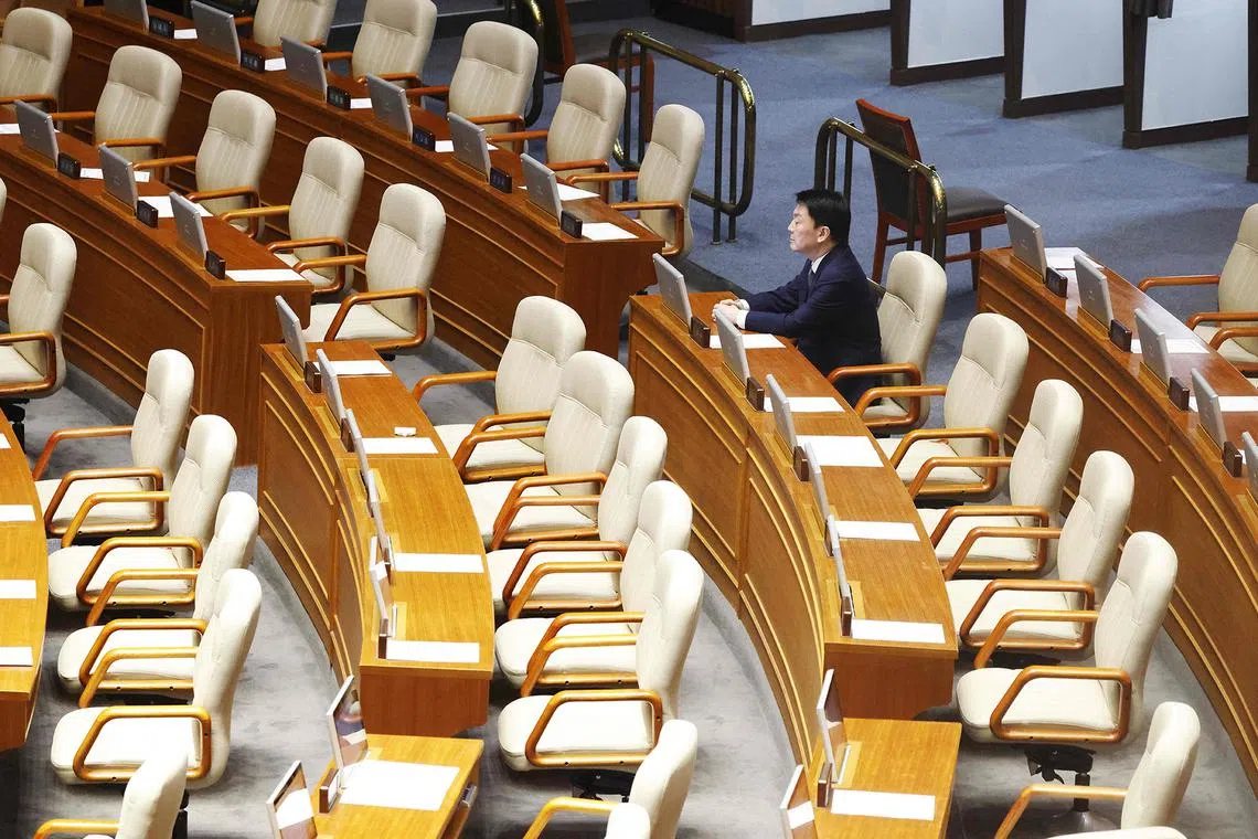 Lawmaker Ahn Chul-soo sits alone, the only People Power Party lawmaker to remain in the voting chamber during the plenary session for the impeachment vote of President Yoon Suk Yeol at the National Assembly in Seoul on December 7, 2024. South Korea's embattled President Yoon Suk Yeol apologised but stopped short of resigning on December 7 over his declaration of martial law, as protesters gathered outside parliament ahead of a crucial impeachment vote that could decide his political fate. (Photo by JEON HEON-KYUN / POOL / AFP)