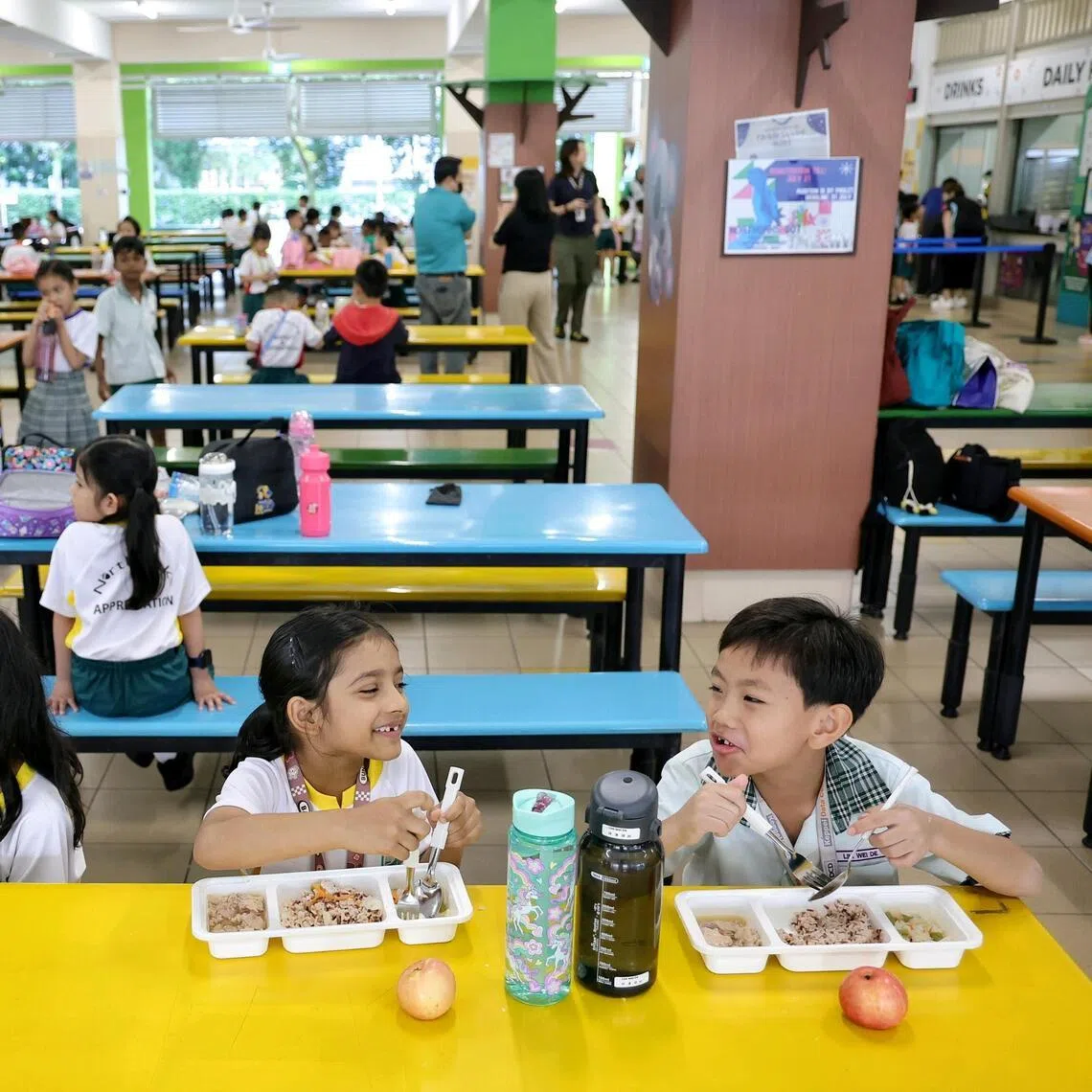 Northoaks Primary School pupils consuming food prepared from a stall and from bento boxes under the central kitchen meal model on Jan 12.