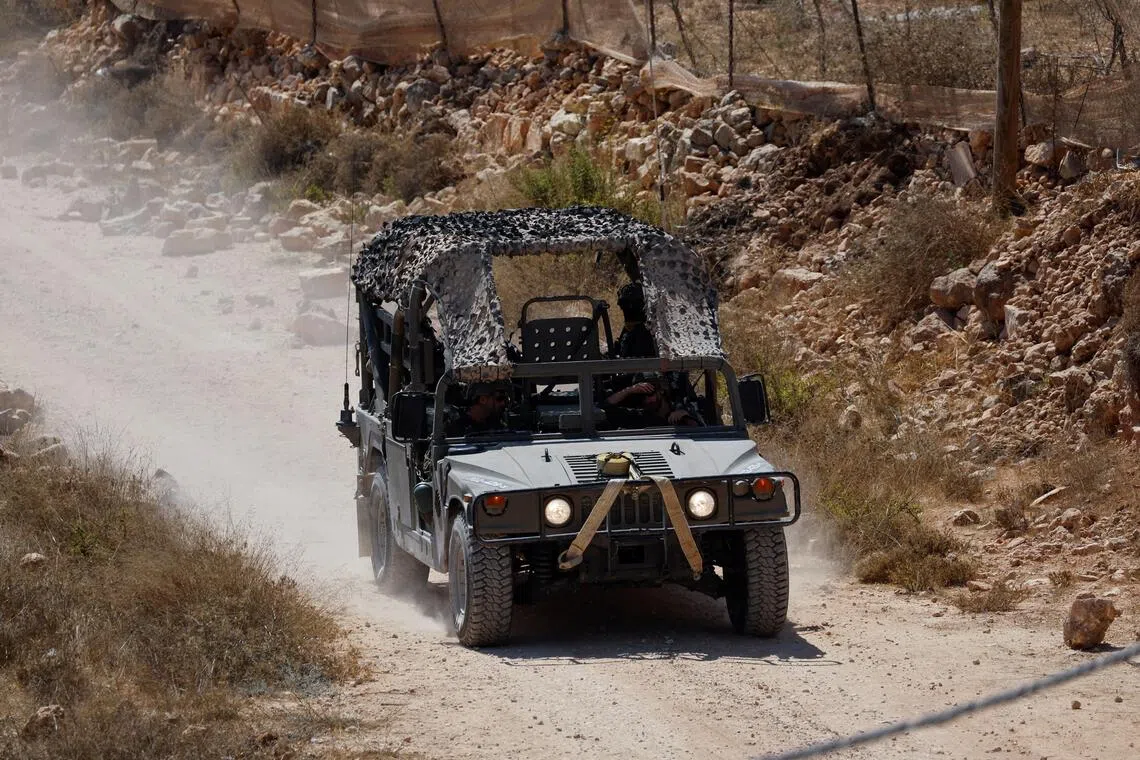 An Israeli military vehicle driving down a road in the Israeli-occupied West Bank on Aug 19.