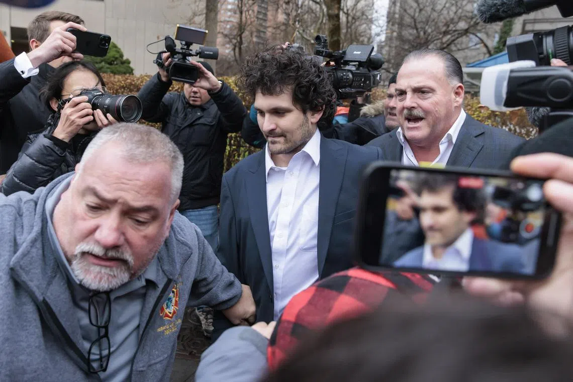 epa10376644 Cryptocurrency entrepreneur Sam Bankman-Fried (C) is lead out of an U.S. Federal Courthouse after being released on bail following an arraignment in New York, New York, USA, 22 December 2022. Bankman-Fried,  who was extradited to the U.S. from the Bahamas on 21 December is facing federal charges that he used money from investors illegally for personal gain.  EPA-EFE/JUSTIN LANE