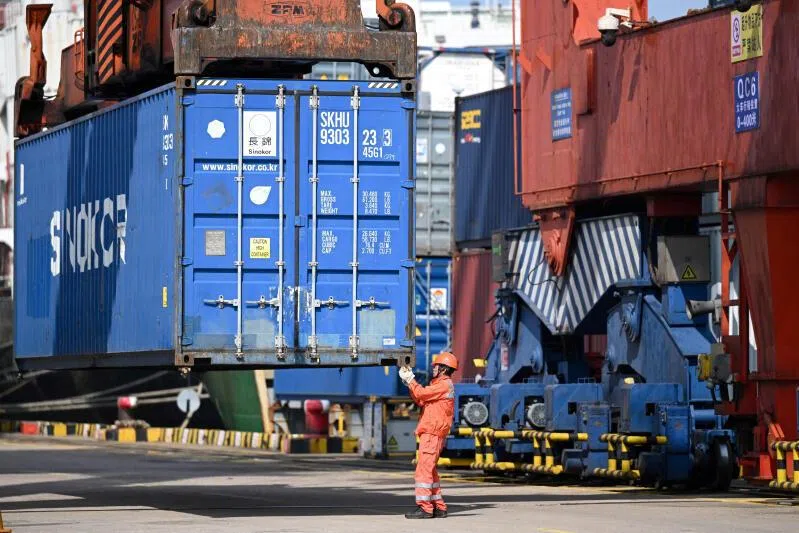 A crane lifts a container at the port of Zhangjiagang, Jiangsu province, China. Inflation risks tied to the global energy shock will dominate Asia’s economic calendar in the coming week.