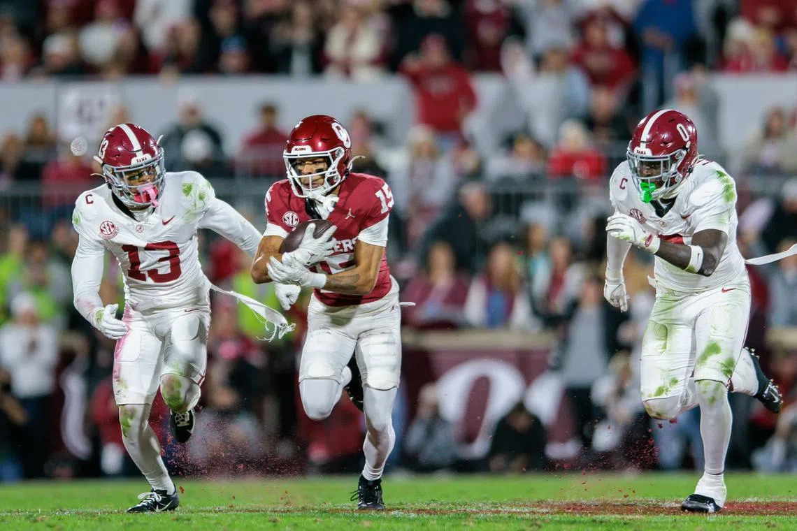 FILE PHOTO: Nov 23, 2024; Norman, Oklahoma, USA; Oklahoma Sooners wide receiver Brenen Thompson (15) runs the ball around Alabama Crimson Tide defensive back Malachi Moore (13) during the third quarter at Gaylord Family-Oklahoma Memorial Stadium. Mandatory Credit: William Purnell-Imagn Images/File Photo