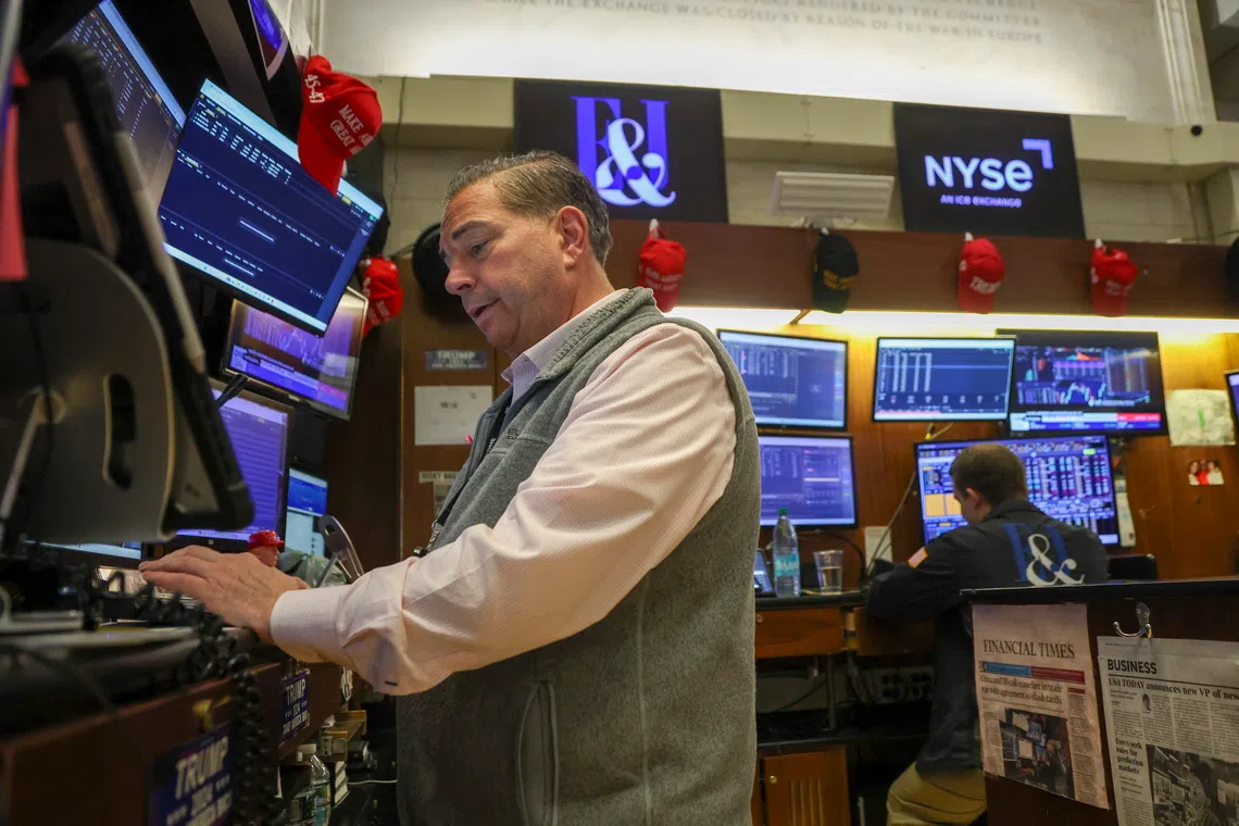 Traders work on the floor of the New York Stock Exchange before the closing bell in New York City on Oct 16.