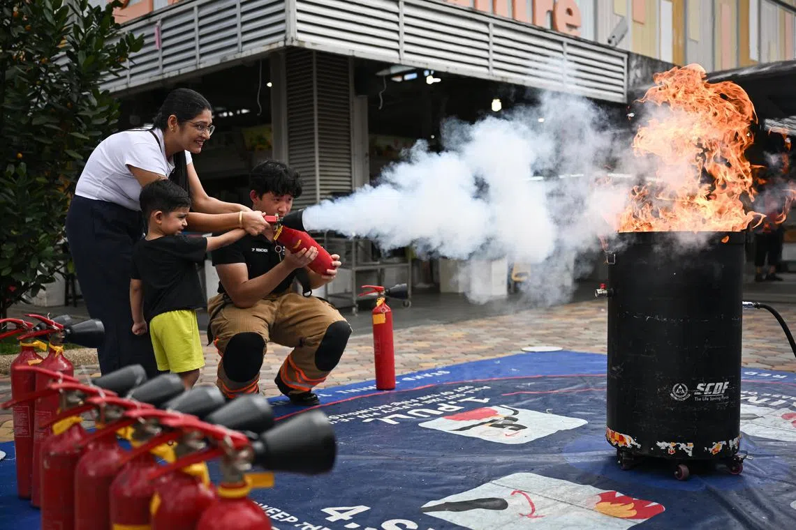 Ms Shaveta, 35, an engineer and her son Viraansh Girdhar, 3, learning how to use the fire extinguisher from CPL Renchen Heng Yi Zhi, 21, a community engagement national serviceman, at the Jalan Besar Community Resilience Day on Mar 1, 2025. 

(ST PHOTO: LIM YAOHUI)