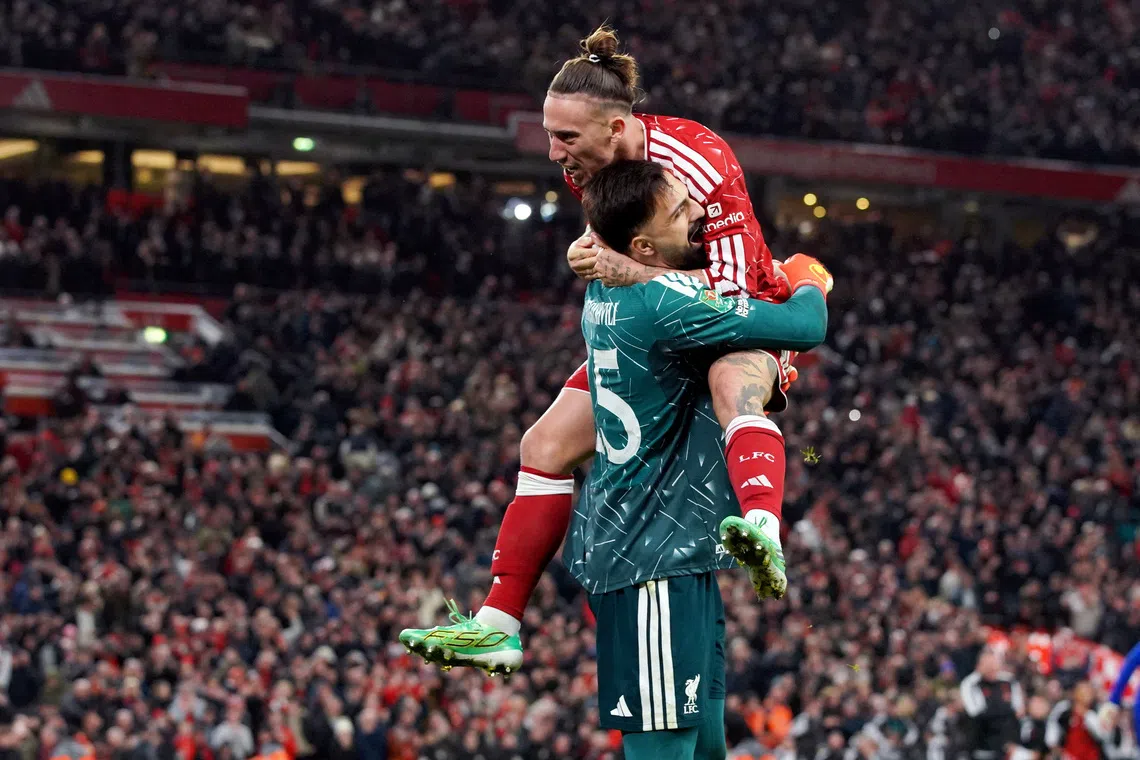Liverpool’s Giorgi Mamardashvili and Kostas Tsimikas celebrate winning the penalty shoot-out.