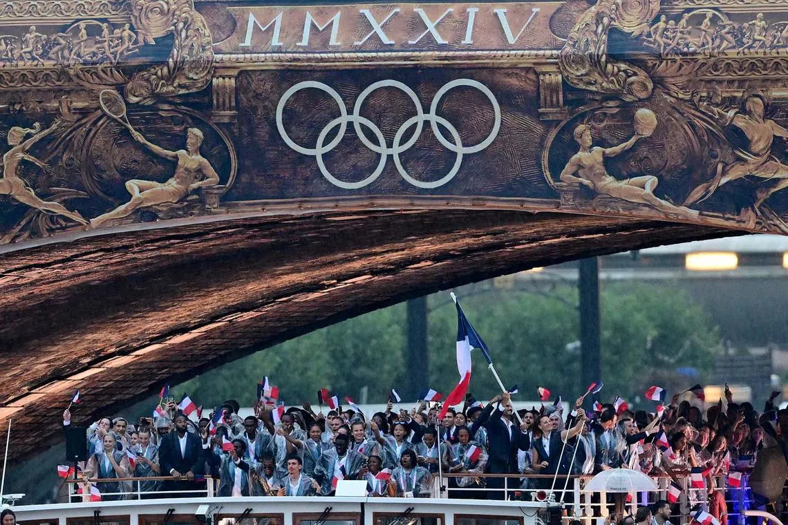 Paris 2024 Olympics - Opening Ceremony - Paris, France - July 26, 2024. Athletes of France are seen on their boat at Pont d'Austrerlitz in the river Seine during the opening ceremony. REUTERS/Angelika Warmuth TPX IMAGES OF THE DAY