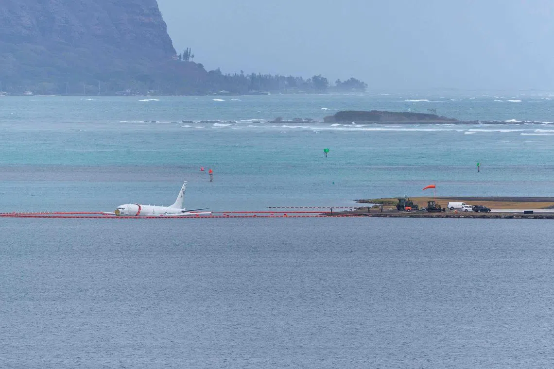 A military aircraft in the shallow waters of Hawaii's Kaneohe Bay after skidding off the end of the runway at Marine Corps Hawaii in Kaneohe on Nov 20, 2023. The aircraft is a Boeing P8 Poseidon, described as a military surveillance and patrol aircraft. Authorities confirmed the nine people on board made it to shore uninjured. 