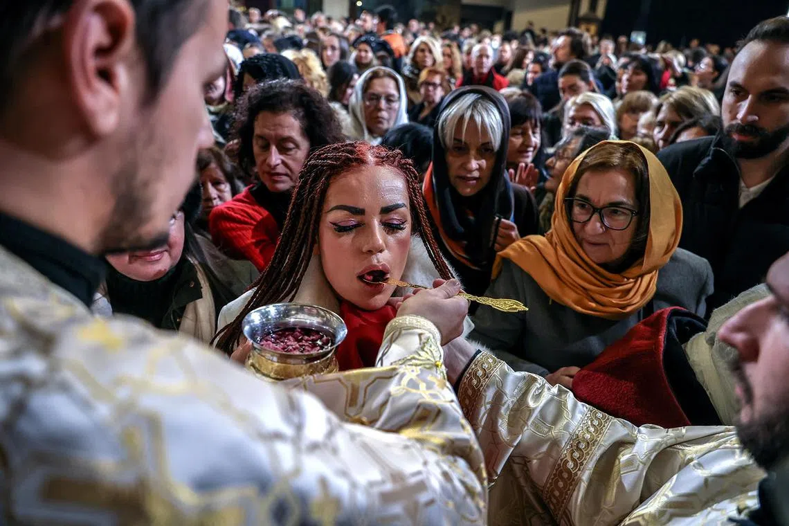An Orthodox priest giving the holy wine and bread to believers following a Christmas Day mass inside the St. Kliment Central Orthodox Church in Skopje, North Macedonia, Jan 7, 2025. Christians associated with Eastern Orthodox churches celebrate Christmas Day on Jan 7, in accordance with the Julian calendar.