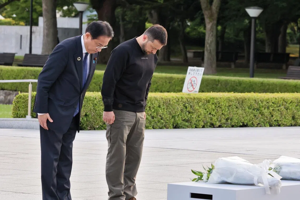 Japan PM Fumio Kishida (left) and Ukraine President Volodymyr Zelensky paying their respects at the Hiroshima Peace Memorial Park on May 21.