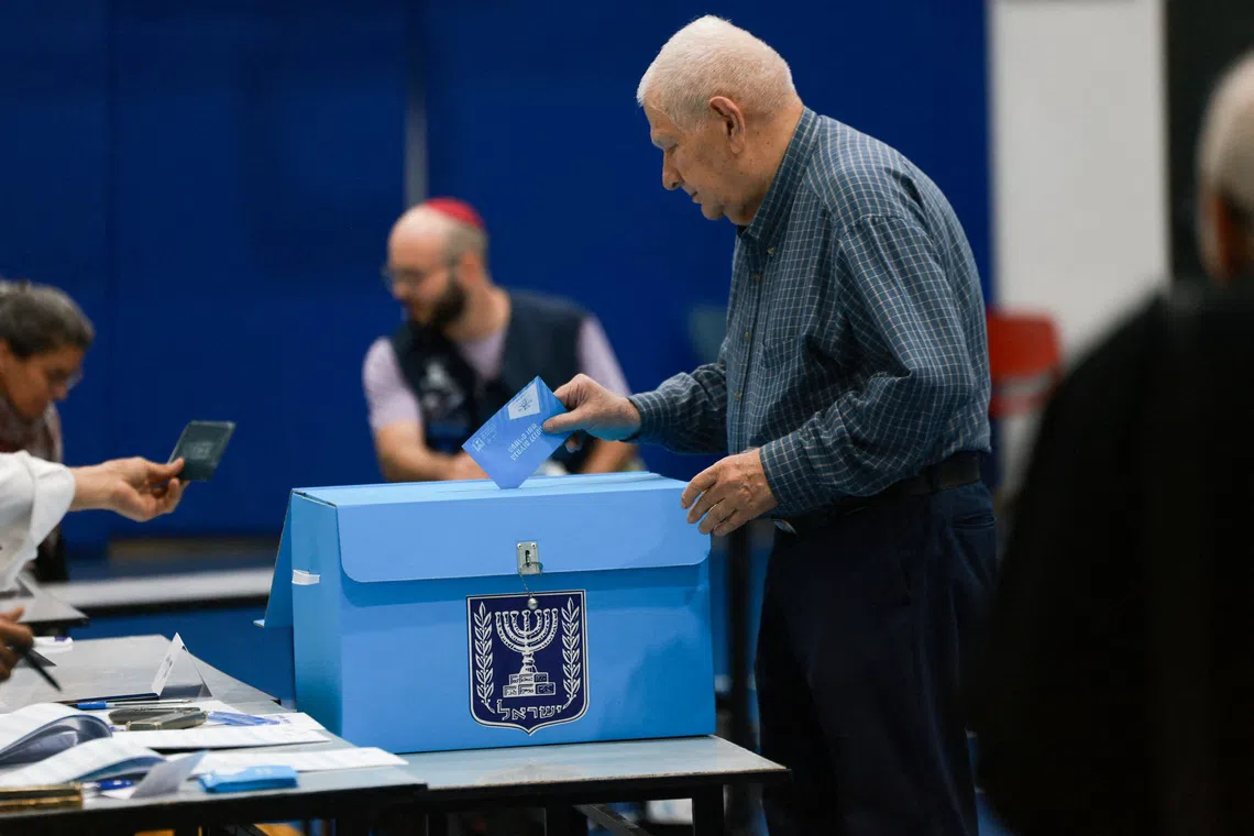 An Israeli man votes at a polling station during Israel’s national election, in Jerusalem on Oct 27.