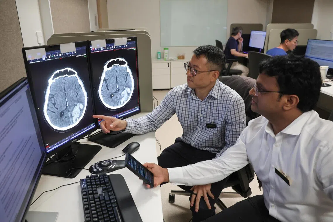 (From left) Robert Chen, head and senior consultant with the neuroradiology department of Singapore General Hospital and National Neuroscience Institute (NNI@SGH) reviewing the AI results and CT scans of patients together with Sarat Kumar Sanamandra, senior consultant of the same department.