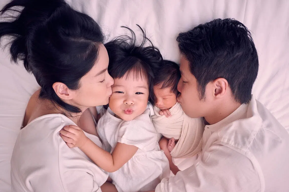 Actress Sheila Sim and her bank executive-husband Deon Woo with their toddler daughter Layla and newborn Skyla.