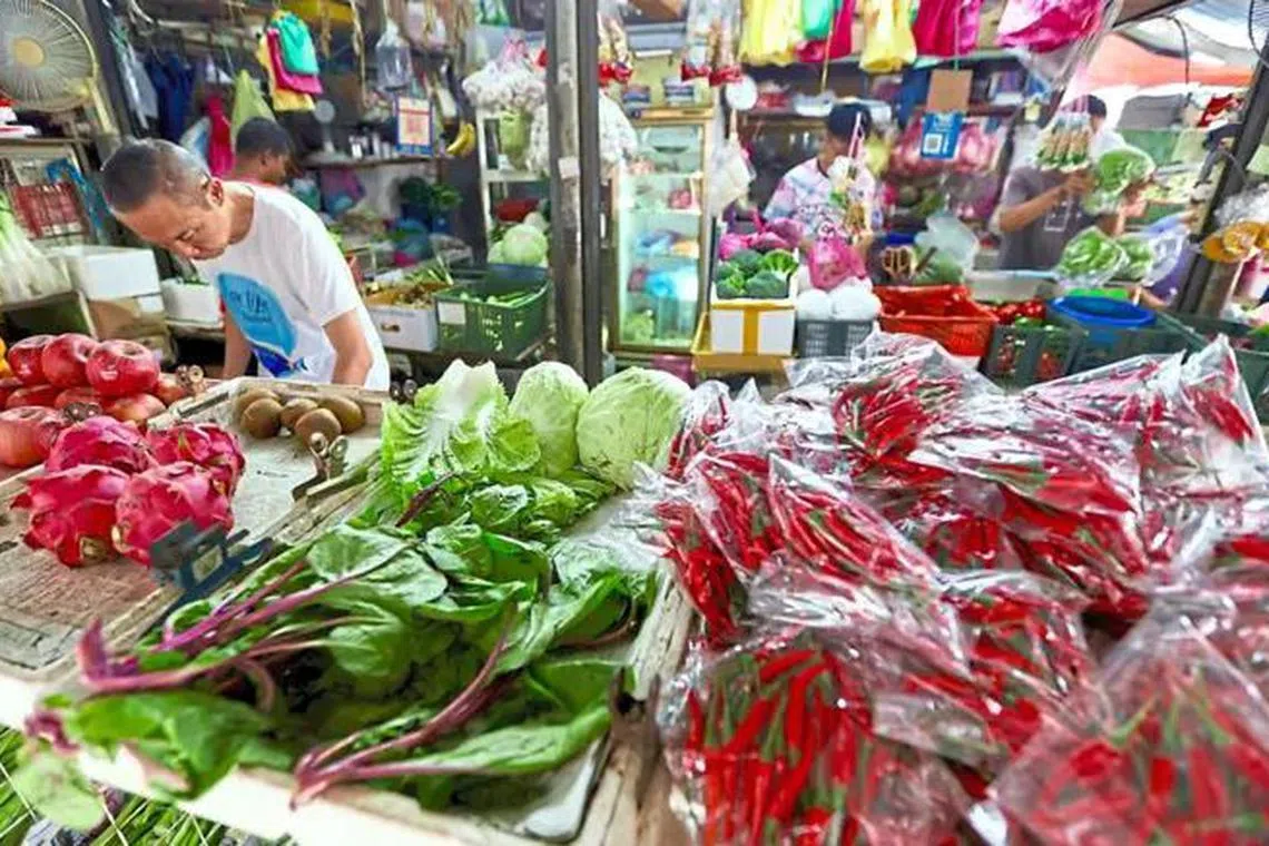 People buying vegetables at Anson Road market in George Town, Penang.