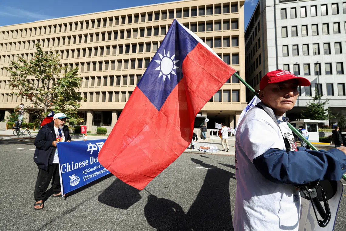 A demonstrator holds a Taiwanese flag during a protest near the White House, on the day of a meeting between Chinese President Xi Jinping and U.S. President Donald Trump in Washington, D.C., U.S., September 24, 2026. REUTERS/Kevin Lamarque