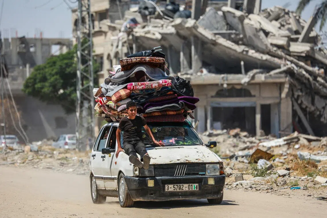 Displaced Palestinians arrive in a car carrying their belongings to set up shelter after returning to Khan Yunis in the southern Gaza Strip on May 9, amid the ongoing conflict between Israel and Palestine.