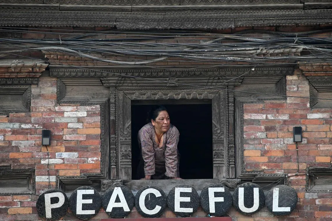 A woman looking out from a window in Bhaktapur on March 14, 2024. 