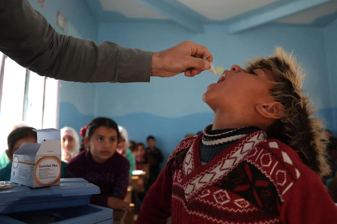 A medic gives the cholera vaccination to a child during a vaccination campaign in the town of Maaret Misrin in the rebel-held northern part of the northwestern Idlib province on March 7, 2023. - Syrian medics launched the first cholera vaccination campaign in the rebel-held northwest since a deadly outbreak began last year, amid increased fears of contagion after last month's devastating earthquake. Health workers were going door to door to inoculate people in homes and displacement camps in the Idlib region, the war-torn country's last main rebel bastion, an AFP correspondent said. (Photo by OMAR HAJ KADOUR / AFP)