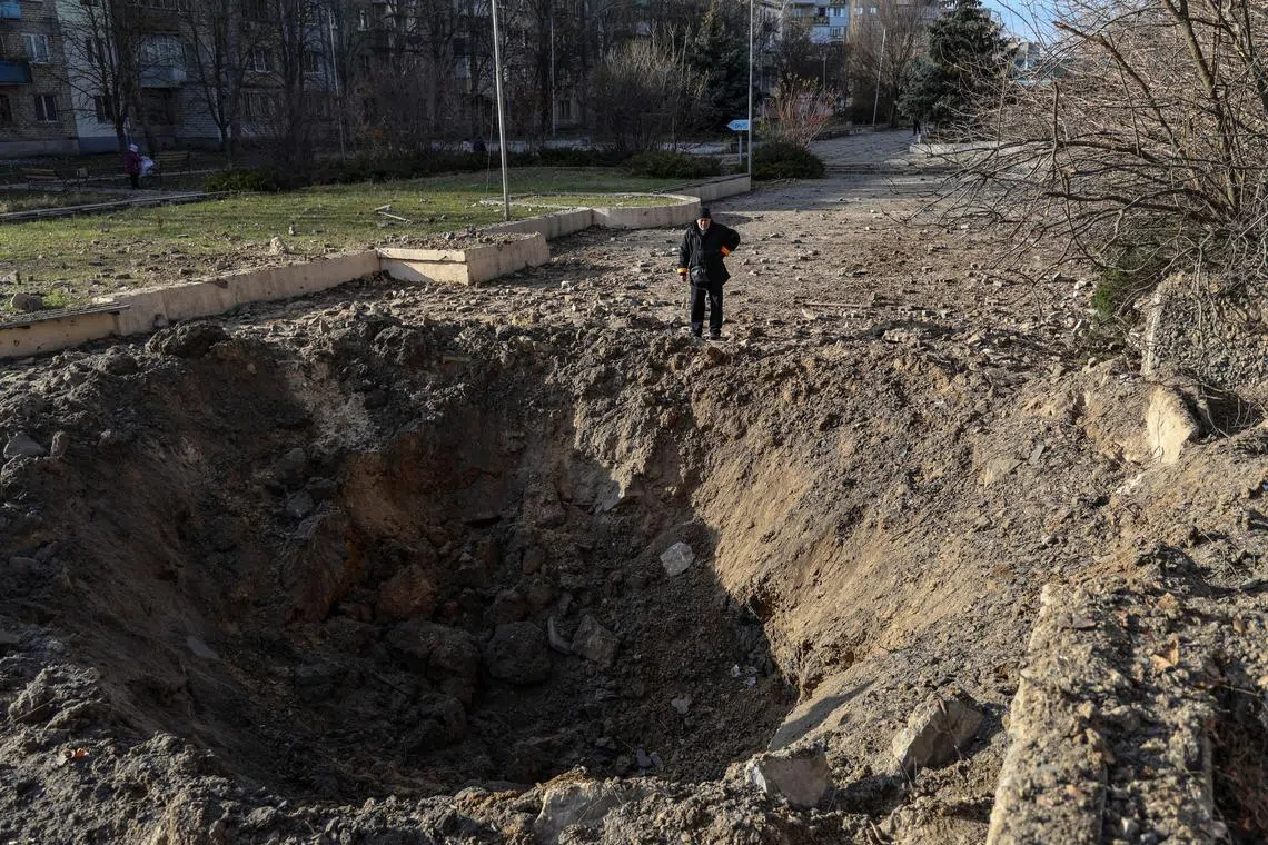 A local resident looks at a crater at the site of a Russian missile strike in Kherson, amid Russia's invasion of Ukraine.