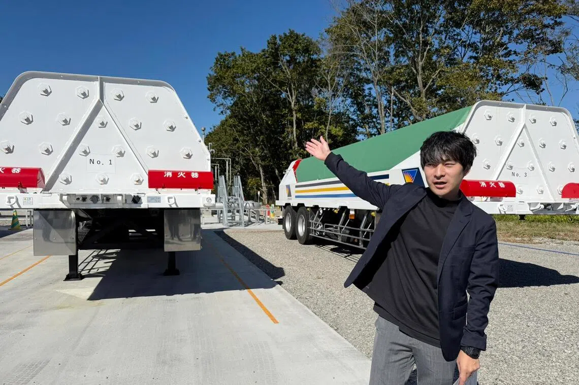 Mr Masaya Kobayashi, vice president of SPARX Green Energy & Technology Ltd, gestures at tanks used to transport hydrogen to its clients.