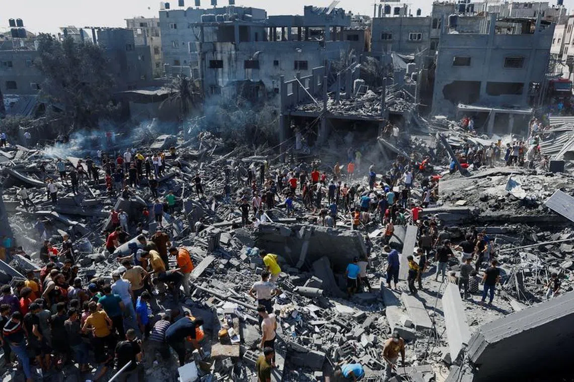 Palestinians search for casualties at the site of Israeli strikes on houses, as the conflict between Israel and Palestinian Islamist group Hamas continues, in Khan Younis in the southern Gaza Strip, October 26, 2023. REUTERS/Ibraheem Abu Mustafa