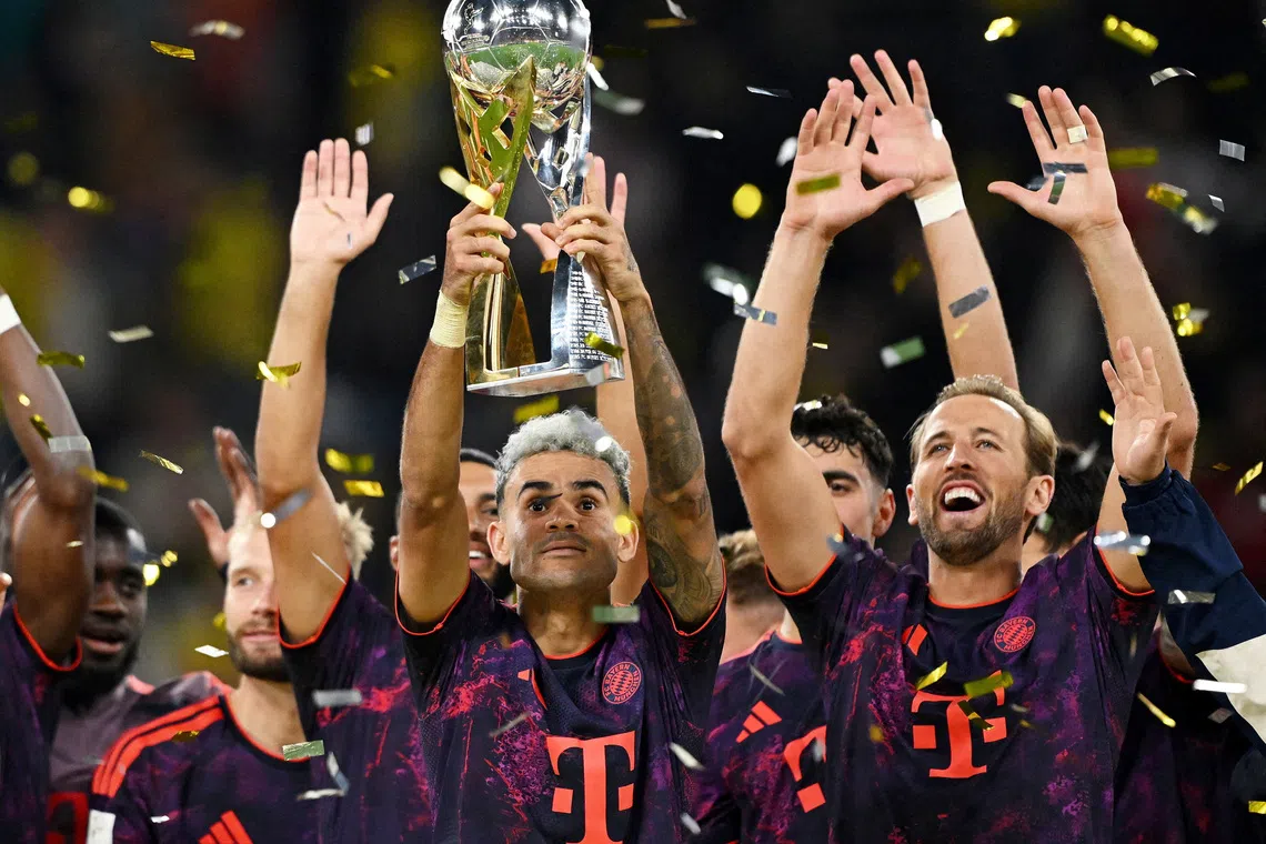 Soccer Football - DFL Supercup - Final - Borussia Dortmund v Bayern Munich - Signal Iduna Park, Dortmund, Germany - August 22, 2026  Bayern Munich's Luis Diaz lifts the trophy with Harry Kane and teammates after winning the DFL Supercup final REUTERS/Teresa Kroeger