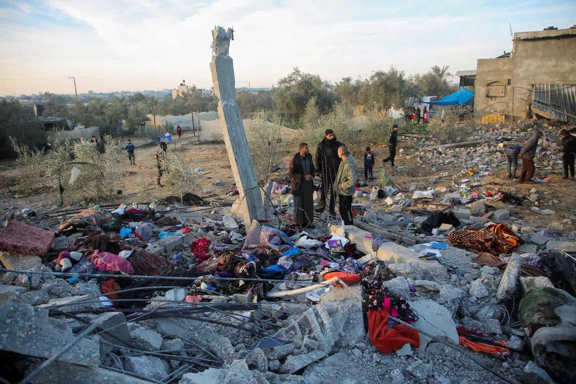 Palestinians inspect the site of an Israeli strike on a house, amid the ongoing conflict between Israel and Hamas, in Khan Younis in the southern Gaza Strip, January 14, 2025. REUTERS/Hatem Khaled