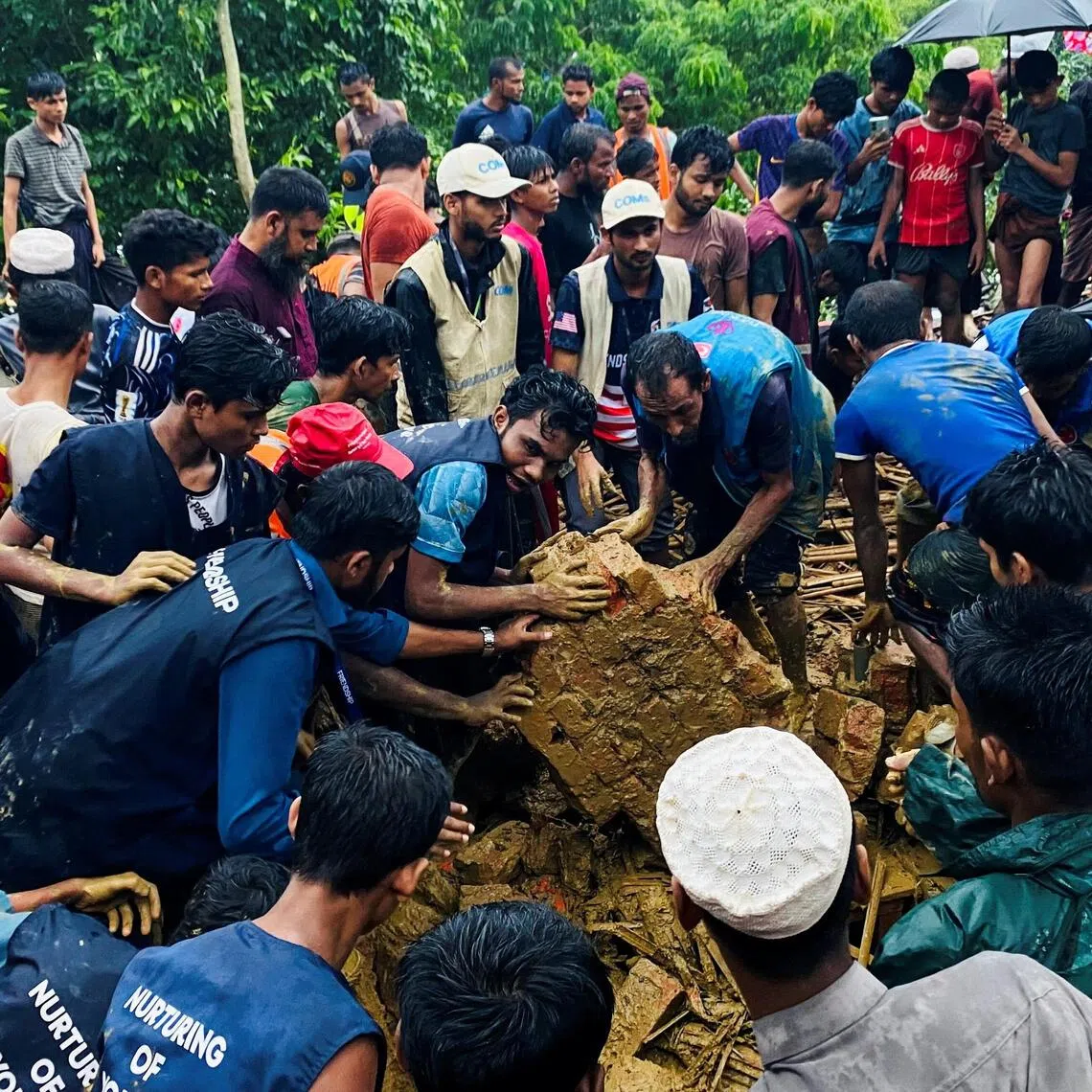 Rohingya refugees works to rescue victims from a landslide spot at a Rohingya Refugee Camp following continuous torrential rain in Cox’s Bazar, Bangladesh.