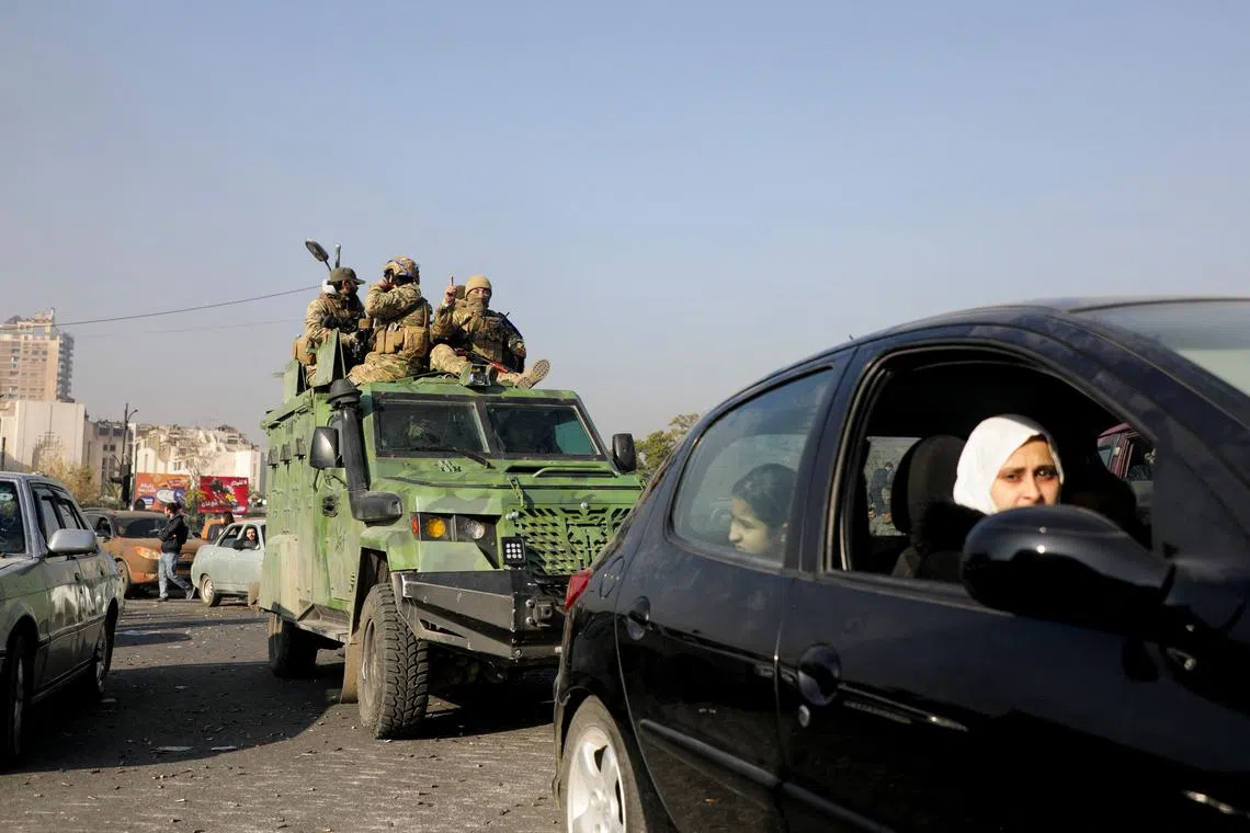 Rebel fighters ride a military vehicle, after they seized the capital and announced that they had ousted President Bashar al-Assad, in Damascus, Syria, December 9, 2024. REUTERS/Mahmoud Hassano