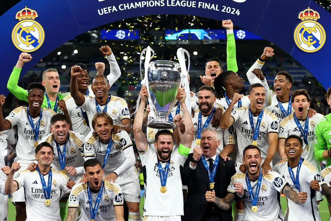 Nacho lifts the trophy as Real Madrid celebrate winning the Champions League.