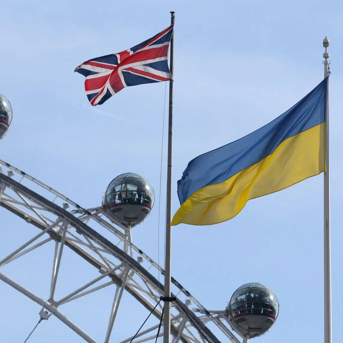 FILE PHOTO: Ukraine flag and British Union flag fly from British government buildings as people ride on the London Eye wheel attraction, in London, Britain, February 23, 2024. REUTERS/Toby Melville/ File Photo