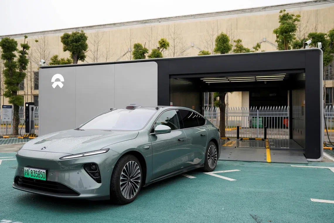 A staff member of Chinese electric vehicle (EV) maker Nio drives a Nio car as he demonstrates to media about the operation of the new battery swapping station, at a delivery center of the company, in Nanxiang, Shanghai, China March 23, 2023. REUTERS/Aly Song