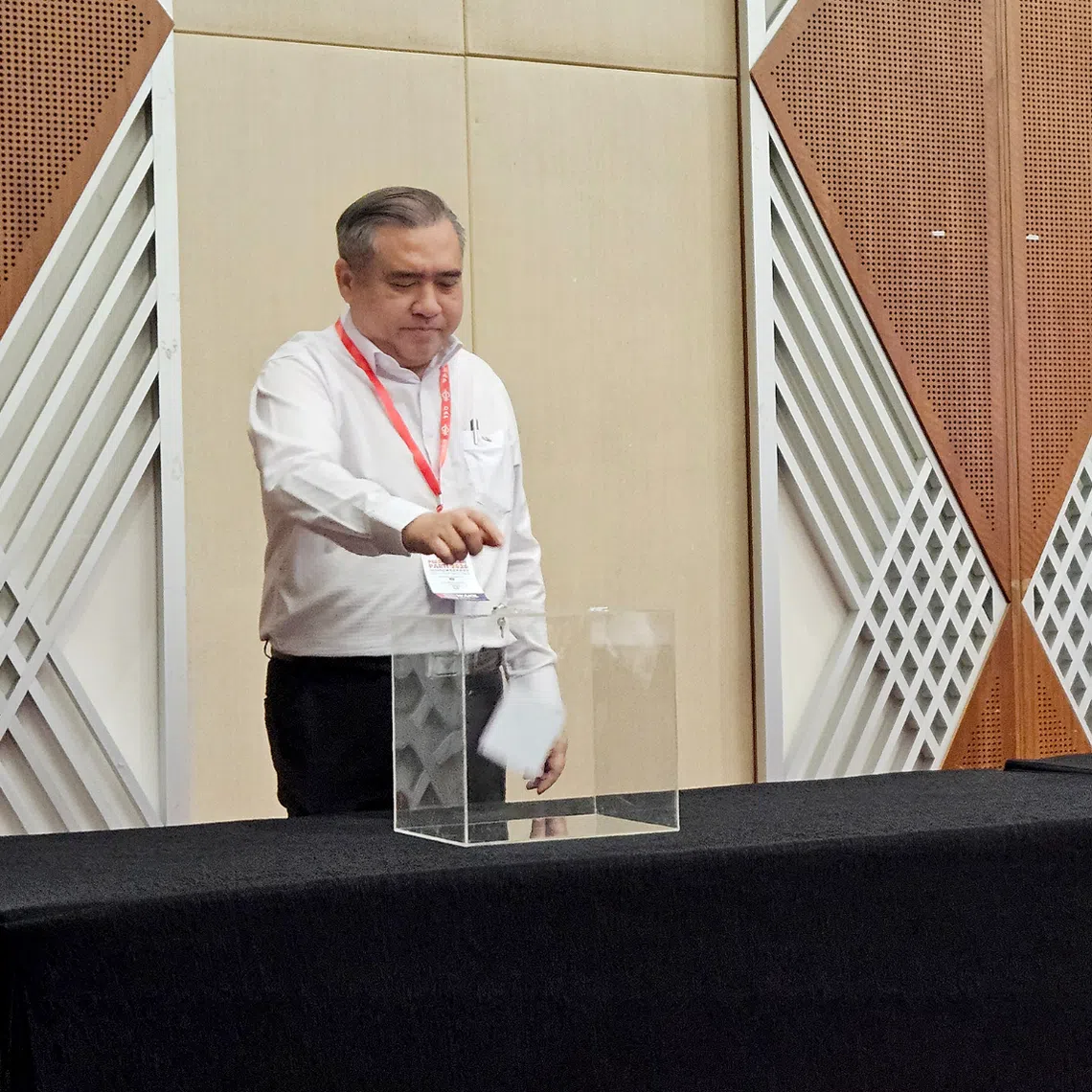 DAP Secretary-General Anthony Loke (left) casting his ballot to decide whether the party should stay in Anwar Ibrahim-led federal government on Aug 16.