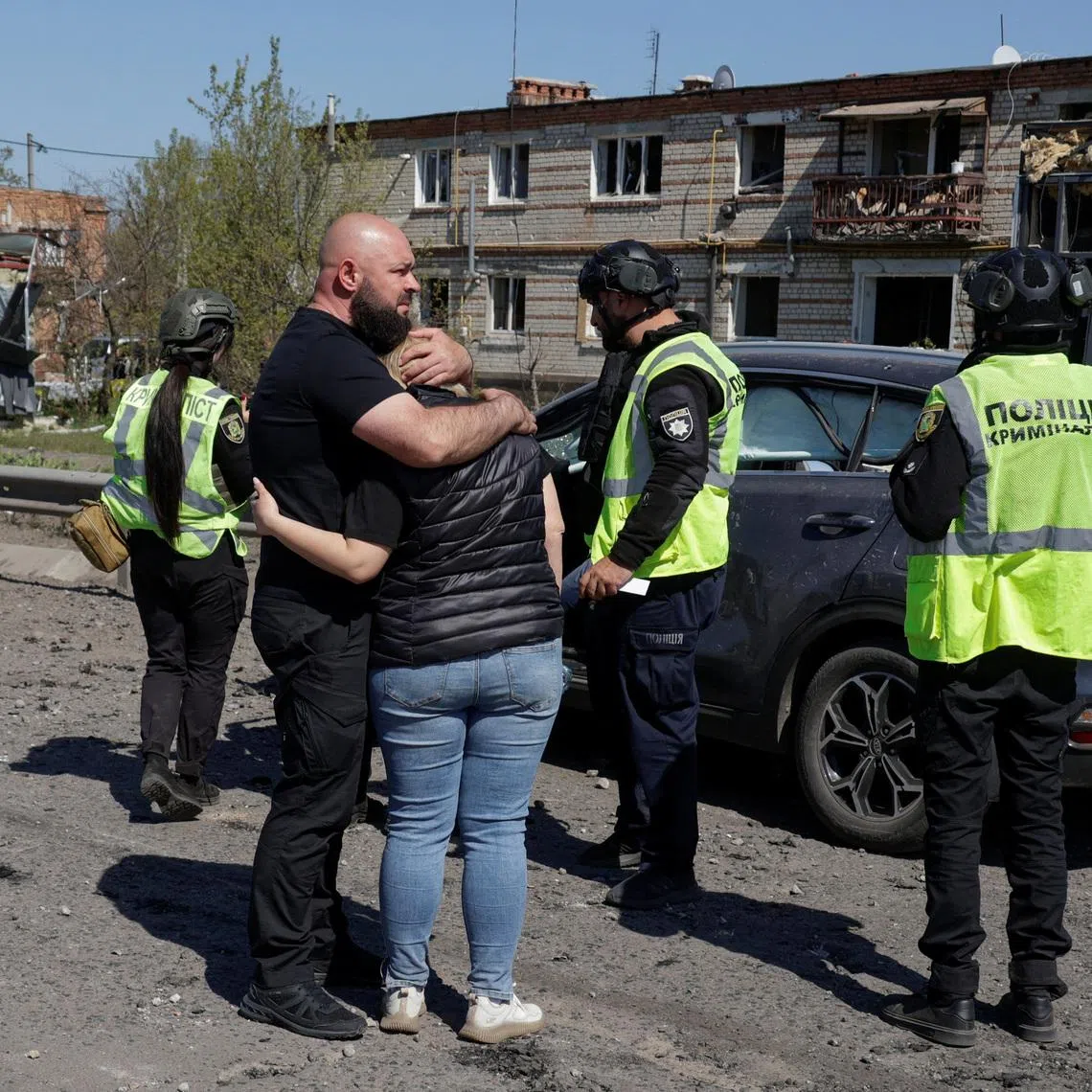 Residents react next to a car with the body of their relative inside who was killed by a Russian missile strike in the town of Merefa, amid Russia's attack on Ukraine, in Kharkiv region, Ukraine May 4, 2026. REUTERS/Sofiia Gatilova