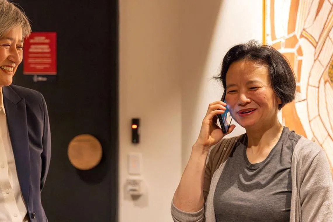 Australian journalist Cheng Lei speaks on the phone, on arrival at Melbourne Airport in Melbourne, October 11, 2023.  AAP Image/Supplied by the Department of Foreign Affairs and Trade (DFAT) via REUTERS