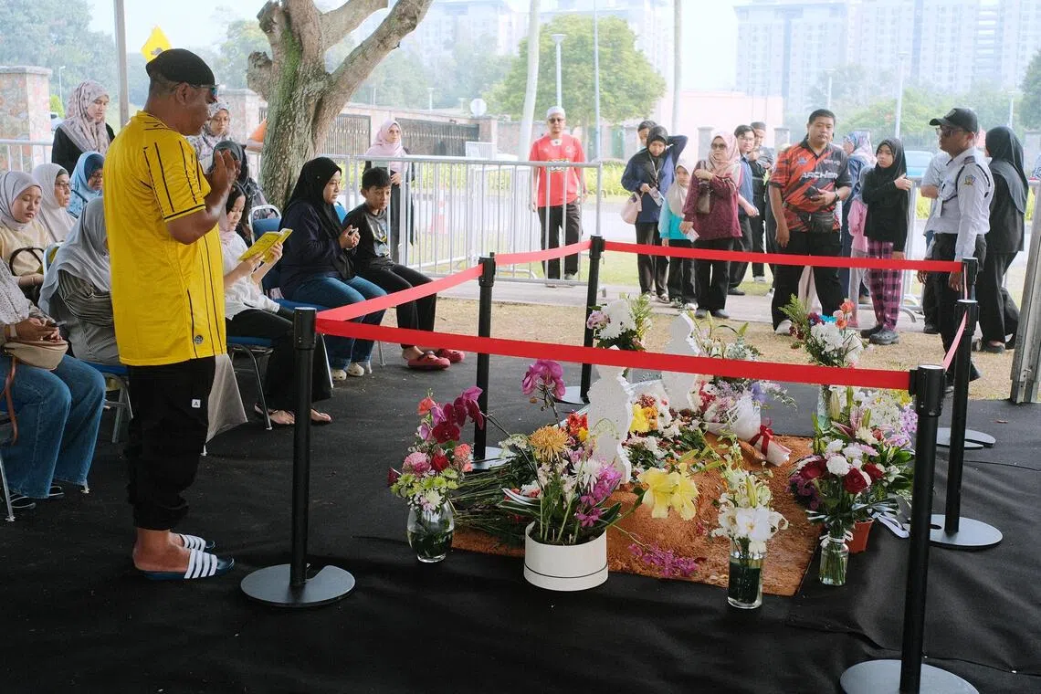 Visitors congregating for a quiet prayer and reflection by the grave of Siti Hasmah Mohamad Ali.