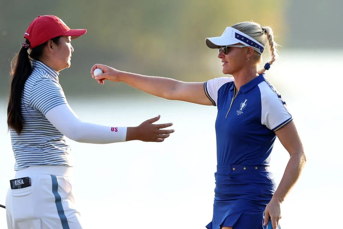Allisen Corpuz of Team United States reacts with Charley Hull of Team Europe on the 18th green during the second day of the Solheim Cup.