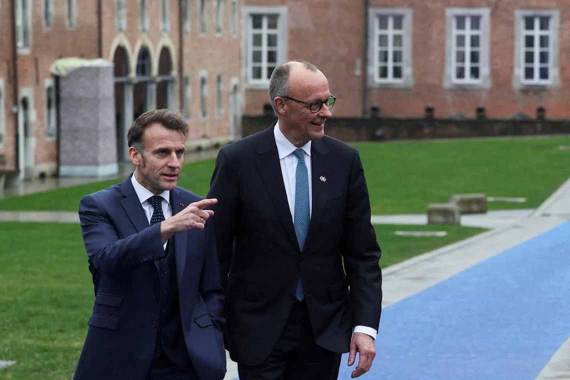Germany's Chancellor Friedrich Merz and France’s President Emmanuel Macron walk at Alden Biesen castle, on the day of an informal European Union leaders retreat, Belgium, February 12, 2026. REUTERS/Murad Sezer