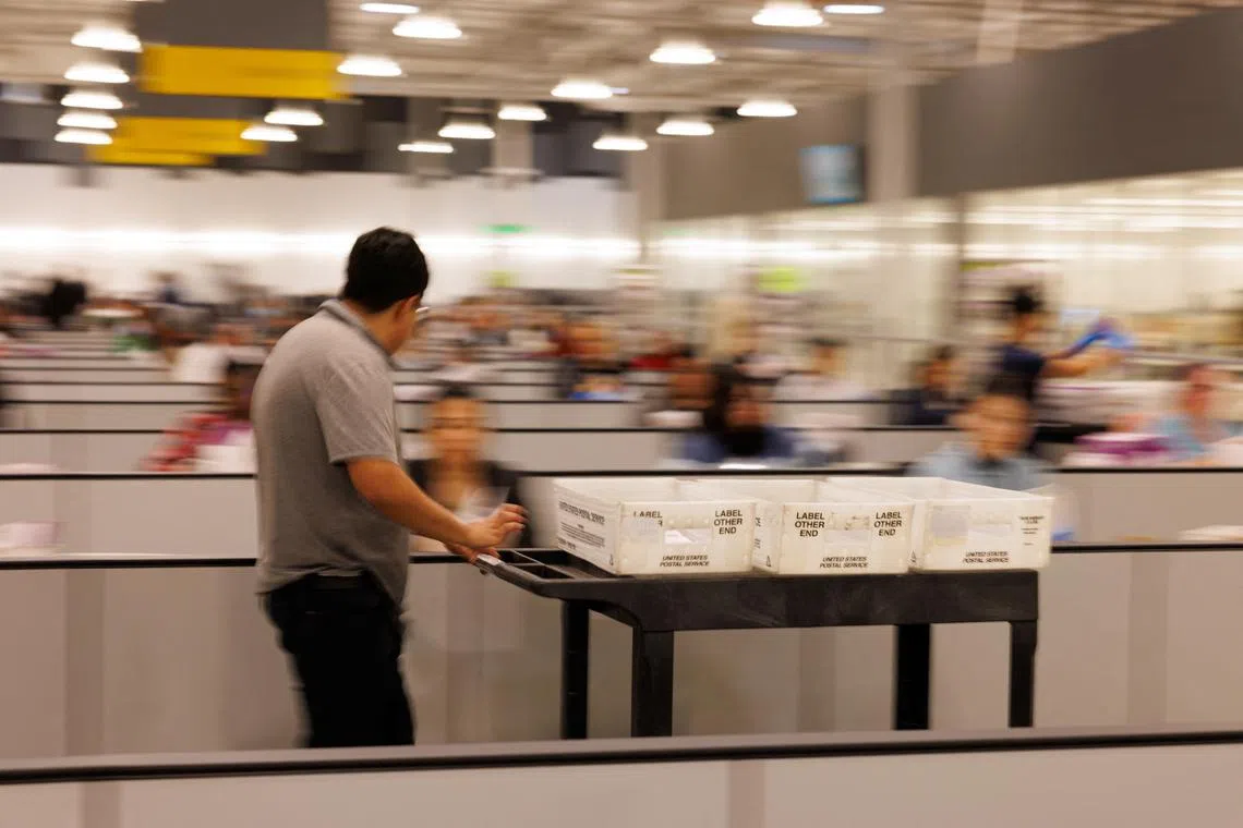 FILE PHOTO: Workers process mail ballots at the Los Angeles County Ballot Processing Center in the city of Industry, California, U.S. October 29, 2024.  REUTERS/Mike Blake/File Photo