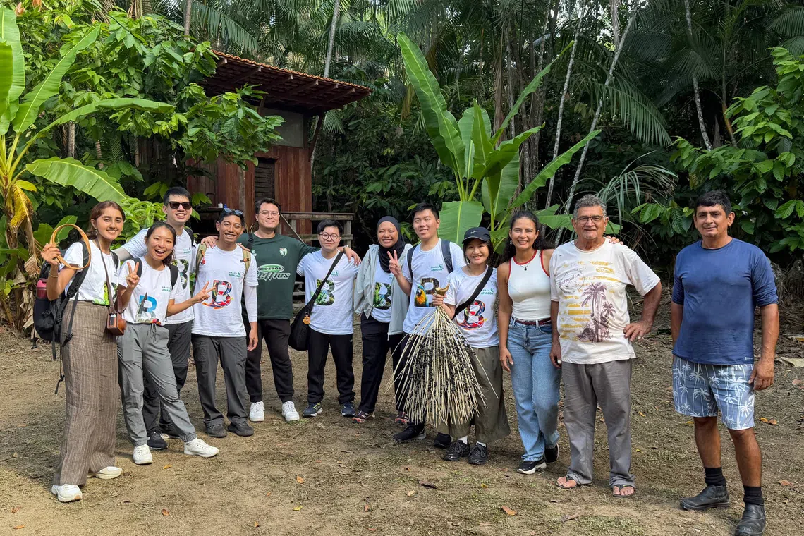 Government staff and the Singapore youth with Combu Island resident Lana Pantoja (third from right) and her family.