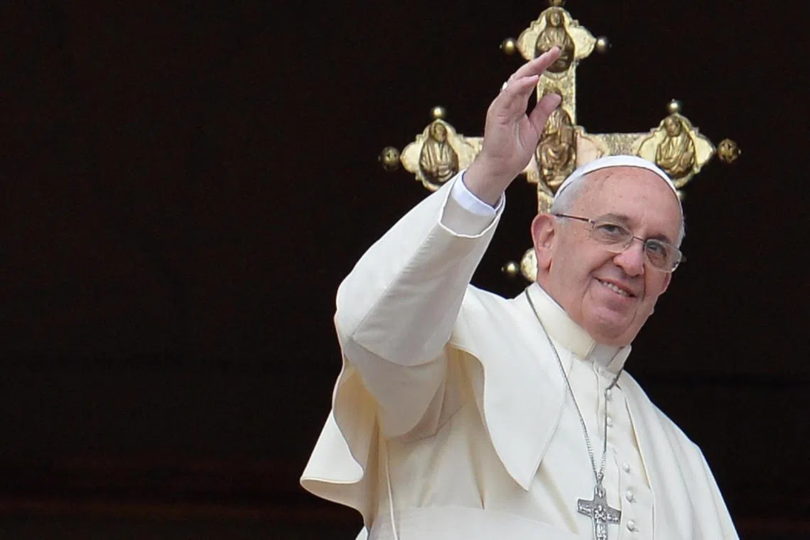 Pope Francis waves to faithfuls after delivering the Urbi et Orbi Christmas Day message on Dec 25, 2013.