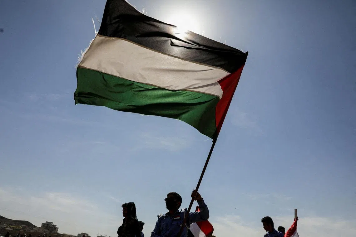 FILE PHOTO: Houthi followers hold a Palestinian flag during a parade in solidarity with the Palestinians in the Gaza Strip and to show support to Houthi strikes on ships in the Red Sea and the Gulf of Aden, in Sanaa, Yemen January 29, 2024. REUTERS/Khaled Abdullah//File Photo
