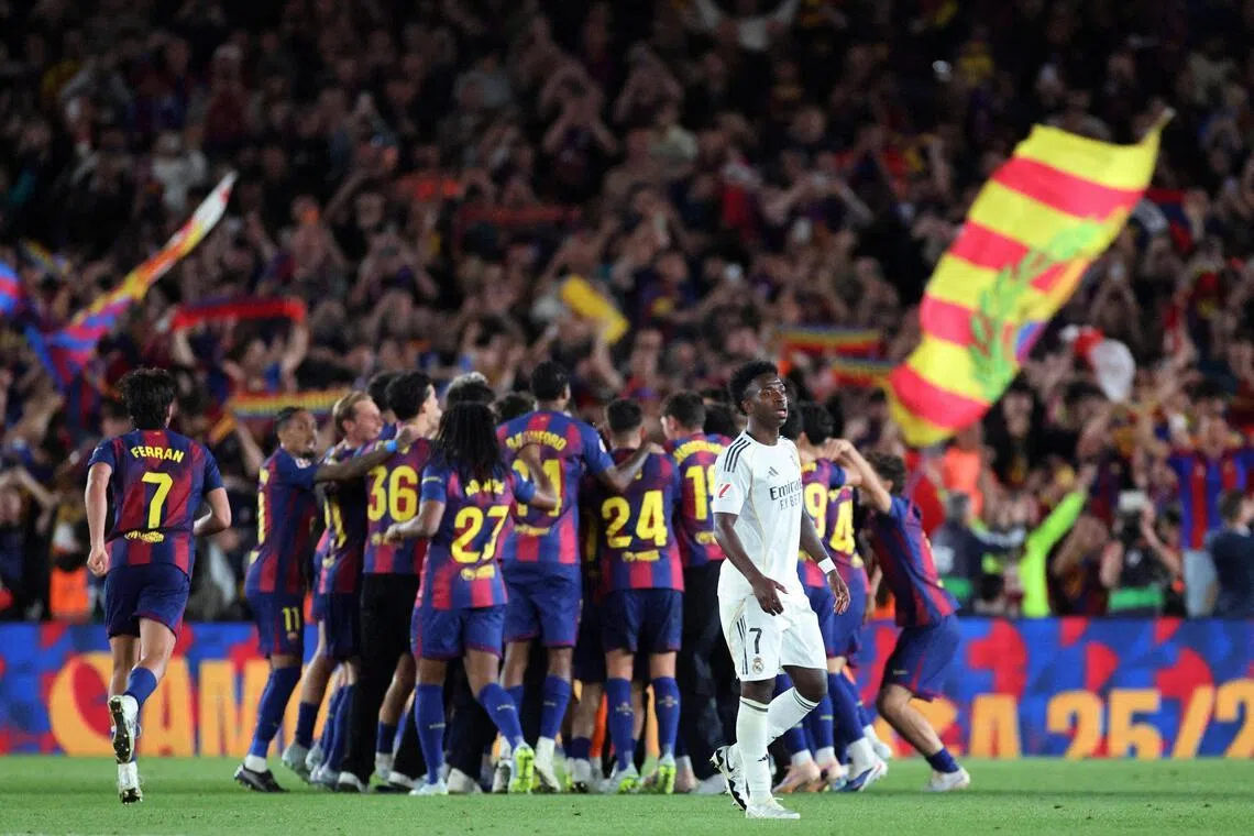 Real Madrid’s Vinicius Junior looking dejected as FC Barcelona players celebrate winning the LaLiga in May 2026.